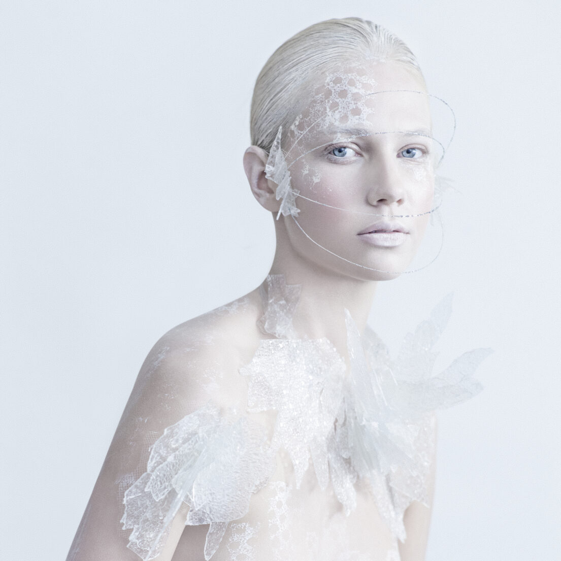 White lace adornment on human figure against a white background.
