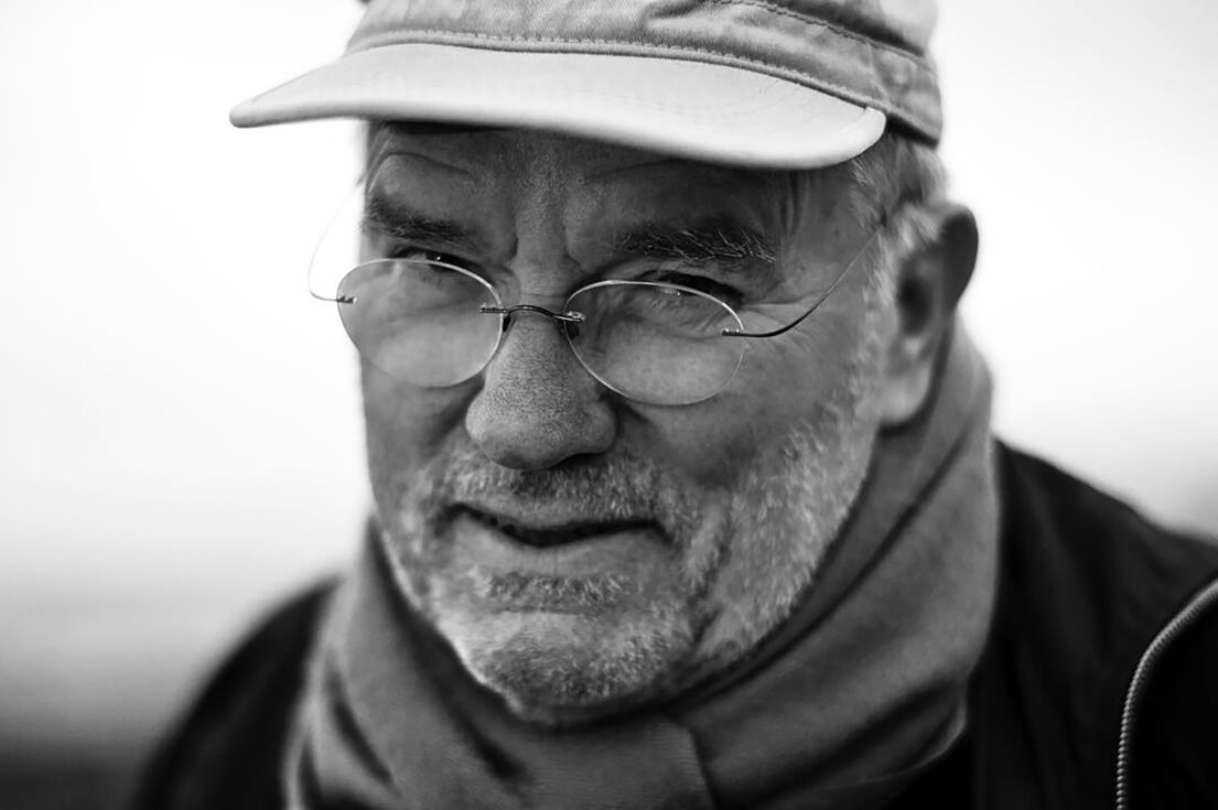 Peter Lindbergh, Elderly man with glasses and cap, looking contemplative.